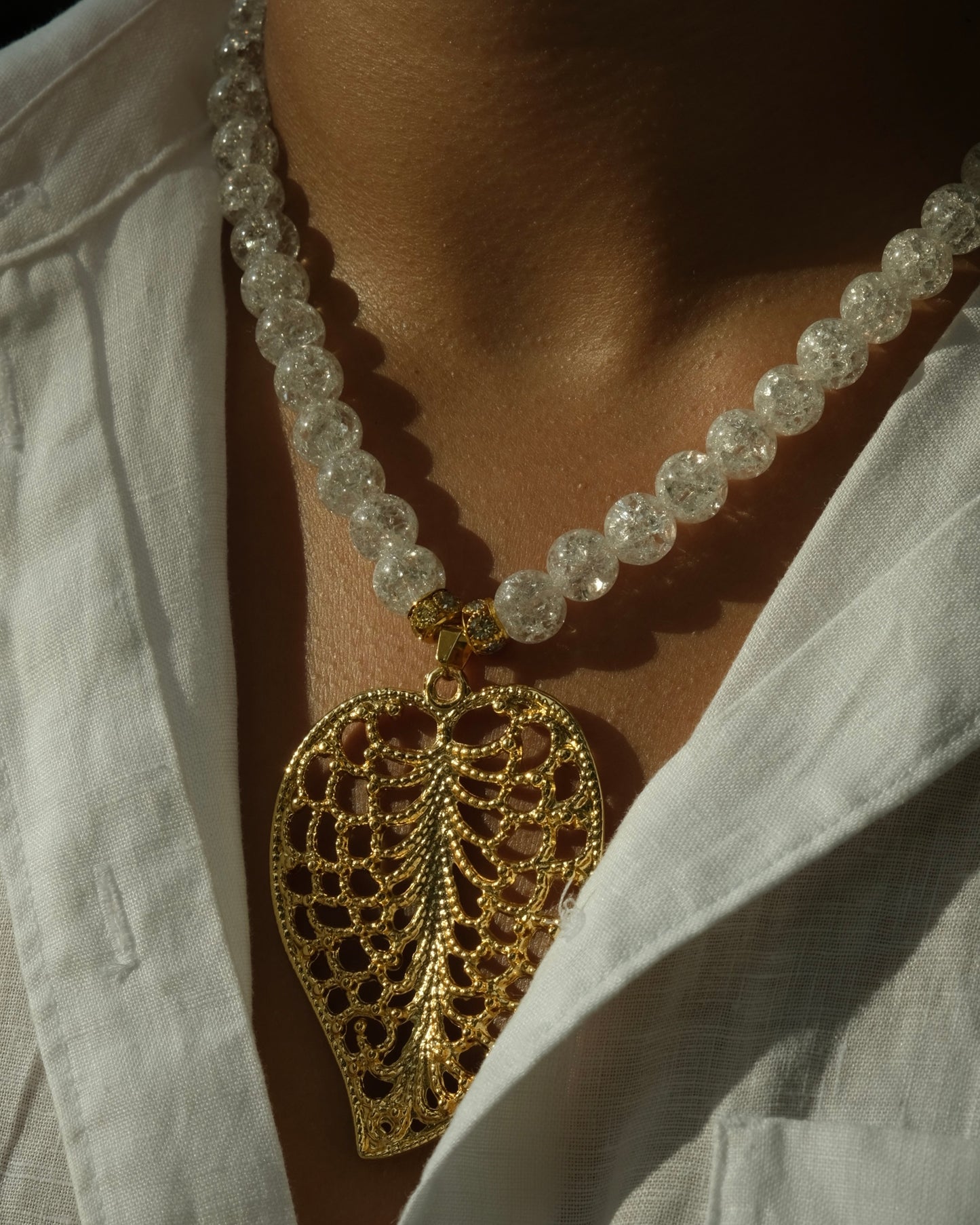 White translucent glittering beads with golden leaf pendent necklace