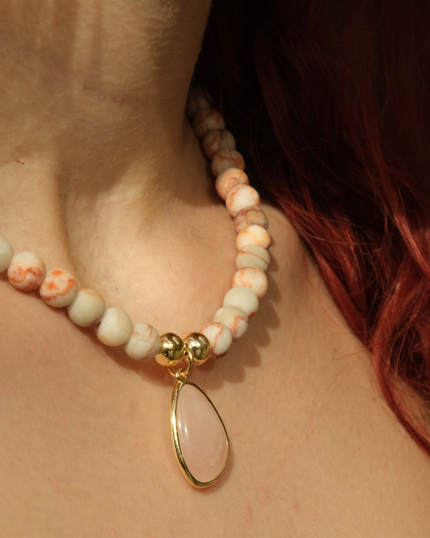 Off white and pink beaded necklace with baby pink and gold pendent